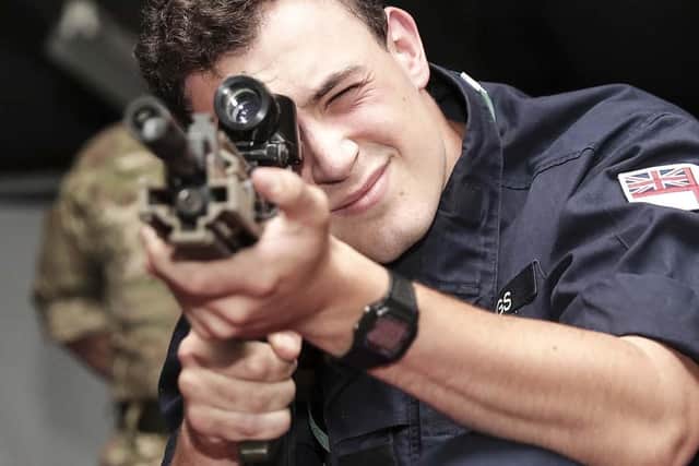 A trainee takes aim at the digital rifle range on HMS Excellent. Photo: Royal Navy