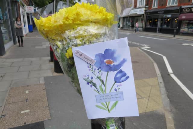 Flowers and a police sign appealing for witnesses have been put in Cosham high street near Vectis Way, where an 85-year-old woman died in a van crash on October 7 2021. Picture: Ben Fishwick