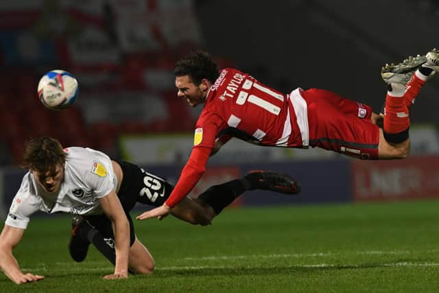 Jon Taylor is challenged by Sean Raggett. Picture: Howard Roe