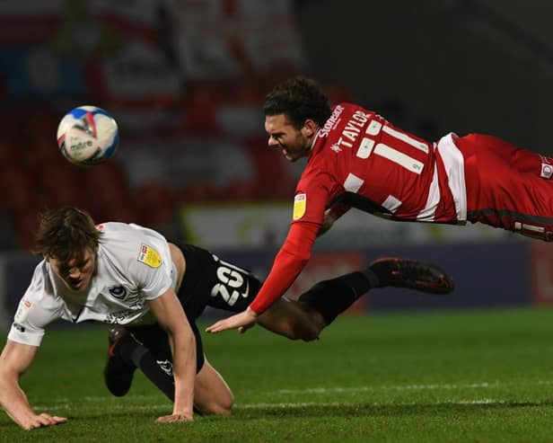 Jon Taylor is challenged by Sean Raggett. Picture: Howard Roe