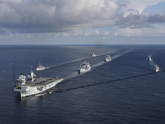 The UK CARRIER STRIKE GROUP during Exercise Joint Warrior. Aerial imagery of the UKCSG Task Group taken from a Merlin Mk2 of 814 Naval Air Squadron.Viewed from the front - HMS Prince of Wales; Row 2 (L-R) – HMS Portland, RFA Tidesurge, HMCS Charlottetown; Row 3 (L-R) – SNS Cristόbal Colόn, RFA Tidespring, HMDS Niels Juel.