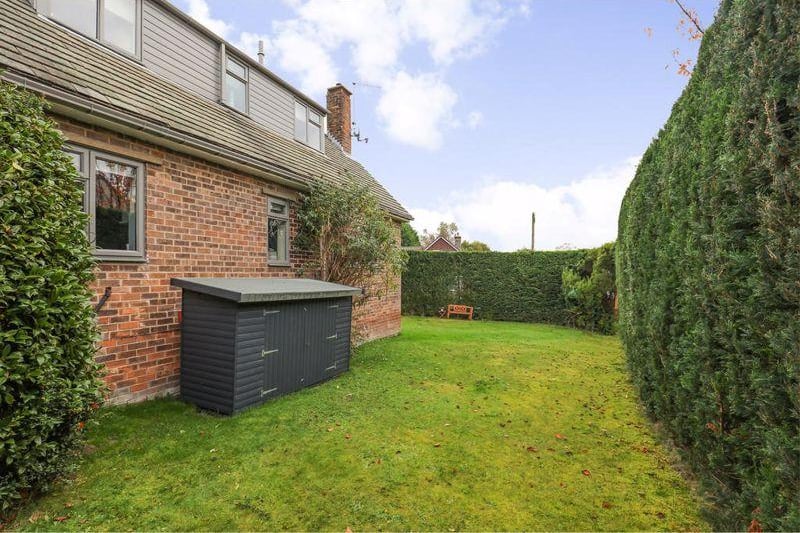 There are lawned gardens to two sides of the property, with manicured conifers providing privacy.