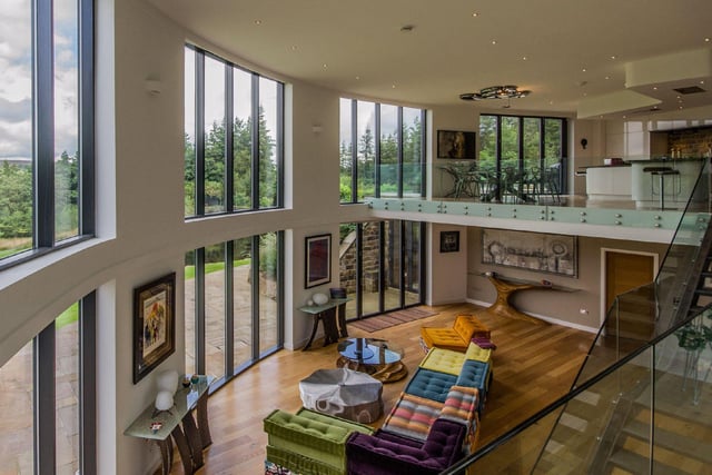 The open plan living space provides a luxurious entertainment area, with a glass viewing platform looking out over the grounds, and several individual sitting areas.
