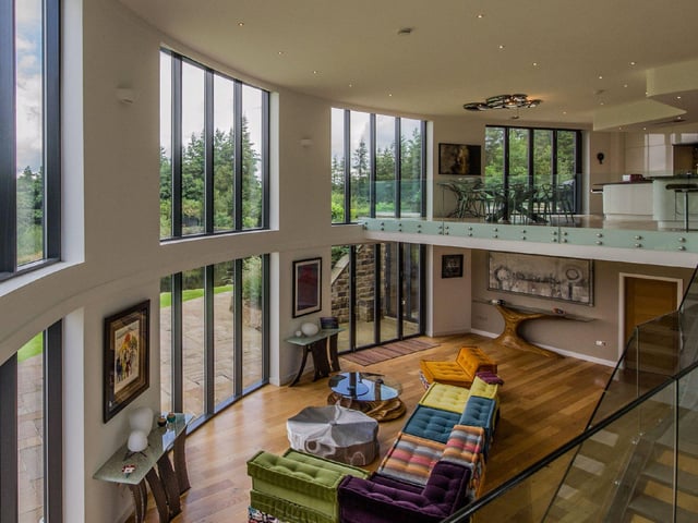 The open plan living space provides a luxurious entertainment area, with a glass viewing platform looking out over the grounds, and several individual sitting areas.