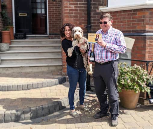 100th customer Peter Clarke celebrates with a bottle of bubbly