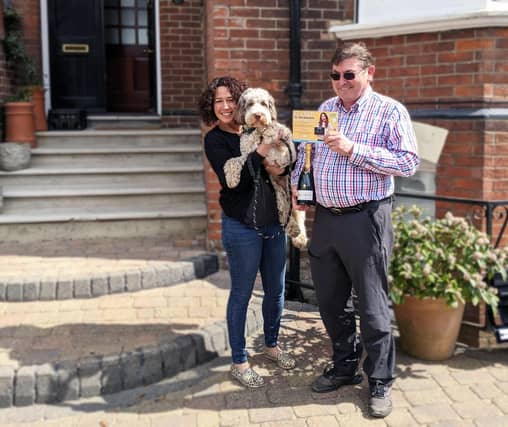 100th customer Peter Clarke celebrates with a bottle of bubbly