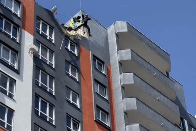 John pictured as his parachute opens after leaping from a bombed-out building in the Ukrainian city of Bucha where two weeks earlier Russian forces had massacred dozens of civilians.