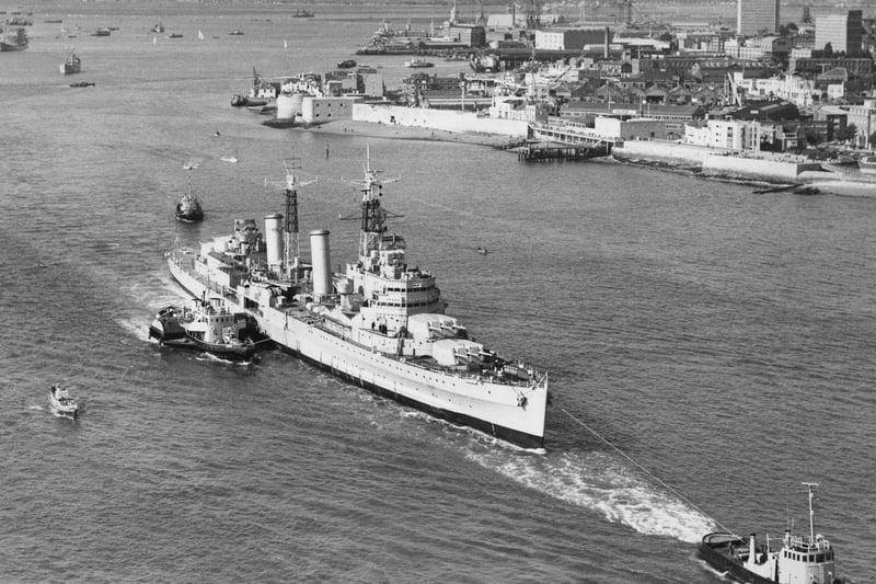 The Royal Navy Town-class light cruiser HMS Belfast is waved away under tow from tugboats on her last voyage from Portsmouth Dockyard to her new berth in London as a floating museum on 2 September 1971 in Portsmouth, United Kingdom. (Photo by Central Press/Hulton Archive/Getty Images).
