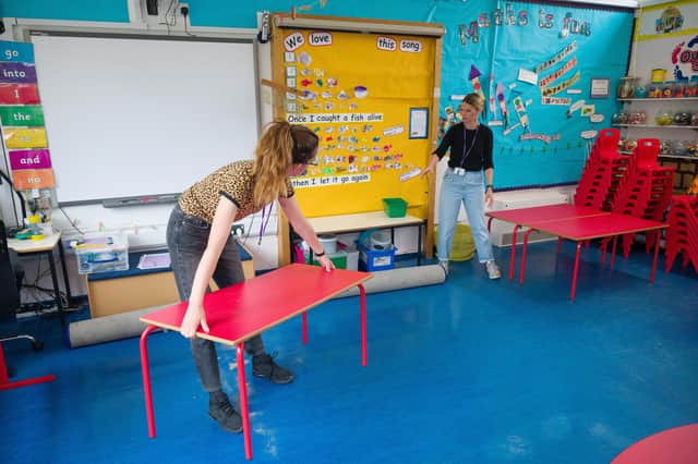 Teaching Assistant Jess Whitfield (L) and teacher Roisin Barker rearrange the desks in a classroom ahead of the return of more students from Reception and Year Six (Photo by Leon Neal/Getty Images)