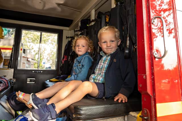 Two-year-old twins Daisy and Charlie Brewer in one of the vintage fire engines. Picture: Mike Cooter (040921)