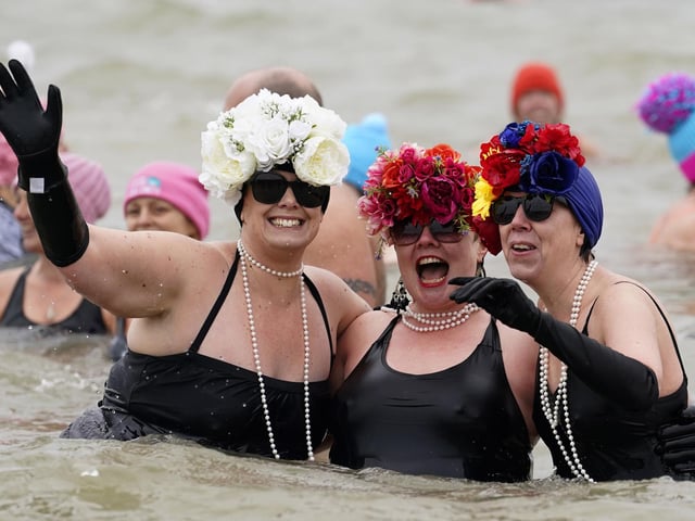 People take part in the Gosport New Year's Day Dip in The Solent at Stokes Bay, Gosport, Hampshire, to raise money for Gosport and Fareham Inshore Rescue Service.