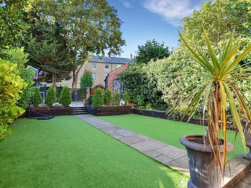 A photo that captures how delightful the back garden is. The central pathway and mature shrubs add to its appearance.
