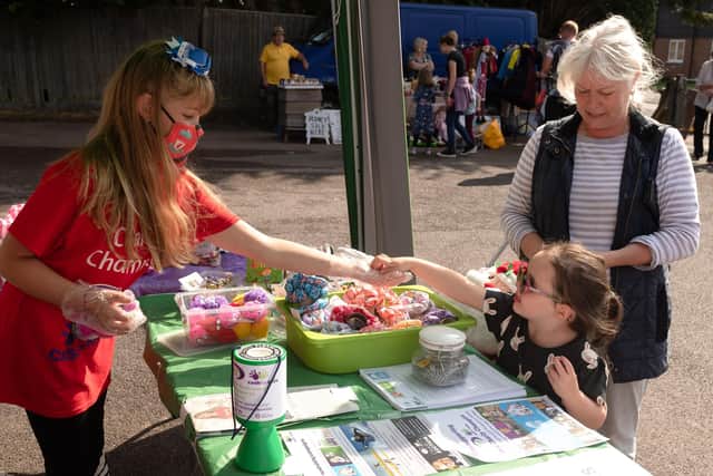 Grace takes a sale from three year old Millie accompanied by her Grandma, Amanda. Picture: Keith Woodland (260921-15)