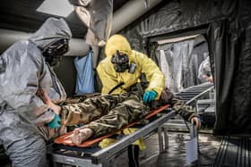 Medics work to decontaminate a mock patient. Image by NATO