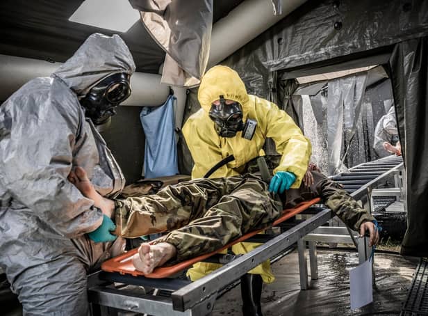 Medics work to decontaminate a mock patient. Image by NATO