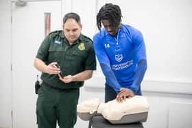 The University of Portsmouth and Portsmouth Football Club are promoting free CPR training for the people of Portsmouth. Paramedic operations manager Jack Ansell with Jayden Reid Picture: Habibur Rahman