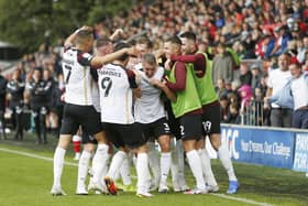 Lee Brown is mobbed by his Pompey team-mates