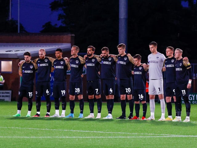 Pompey players stand in arm in arm during the minute silence in respect of the late Queen.