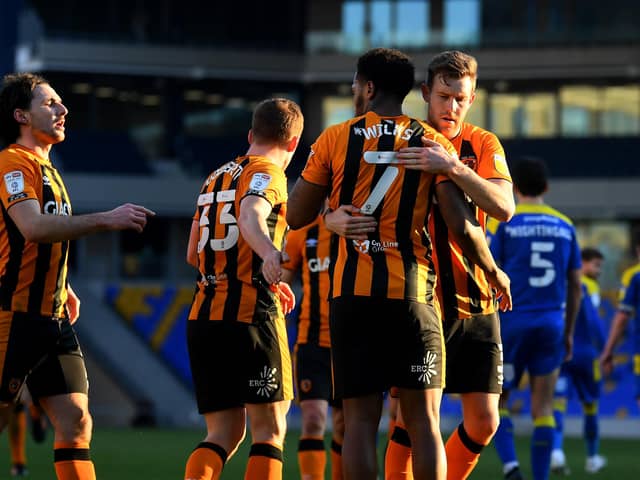 WIMBLEDON, ENGLAND - FEBRUARY 27: Mallik Wilks of Hull City celebrates with Callum Elder after scoring their team's third goal from the penalty spot during the Sky Bet League One match between AFC Wimbledon and Hull City at Plough Lane on February 27, 2021 in Wimbledon, England. Sporting stadiums around the UK remain under strict restrictions due to the Coronavirus Pandemic as Government social distancing laws prohibit fans inside venues resulting in games being played behind closed doors. (Photo by Alex Davidson/Getty Images)