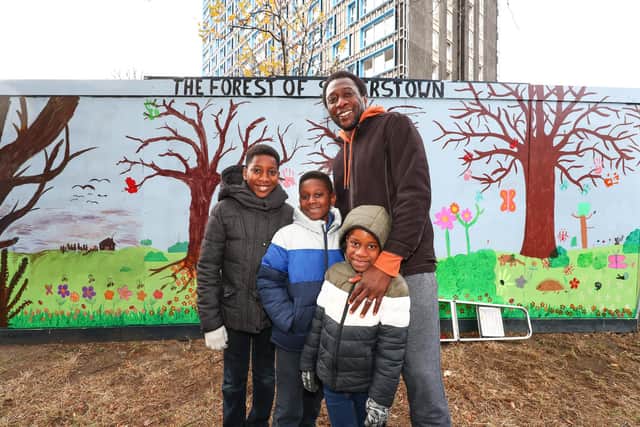 Anthony Ogbeche and his sons Taddeo, Tacey and Tychawn in front of the mural.
Picture: Stuart Martin (220421-7042)
