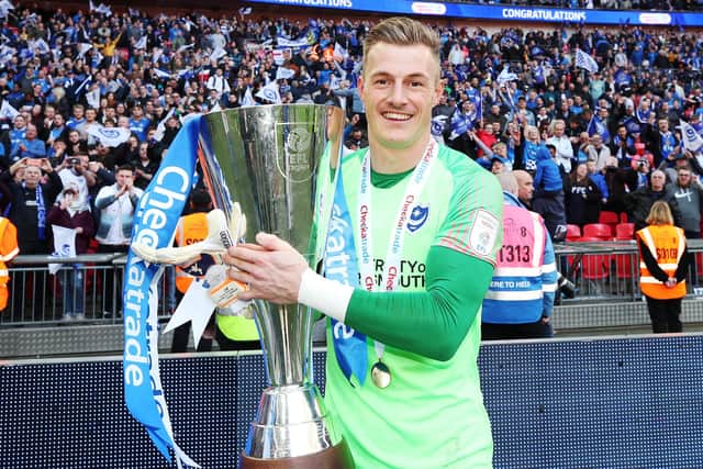 Craig MacGillivray celebrates with the Checkatrade Trophy after Pompey's triumph in March 2019. Picture: Joe Pepler