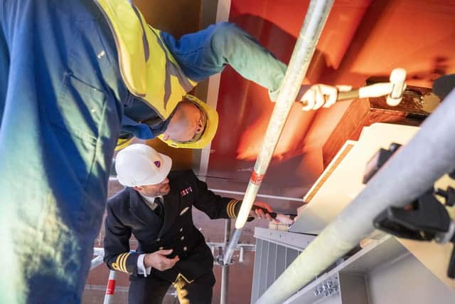 Cdr Chris Couzens and apprentice Robbie Dick place the ceremonial coin under the keel. Picture: Royal Navy.