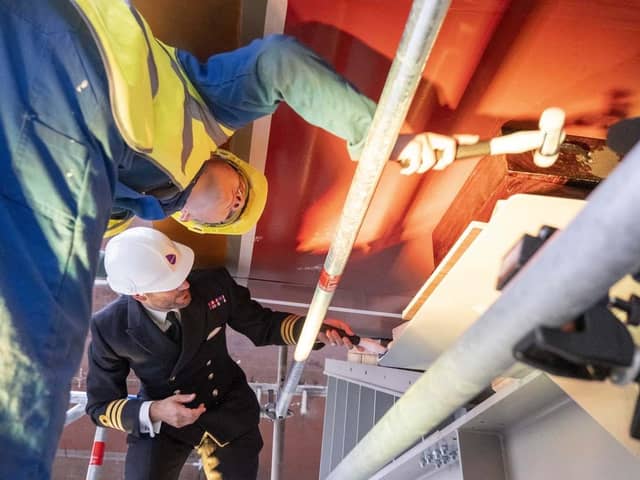 Cdr Chris Couzens and apprentice Robbie Dick place the ceremonial coin under the keel. Picture: Royal Navy.