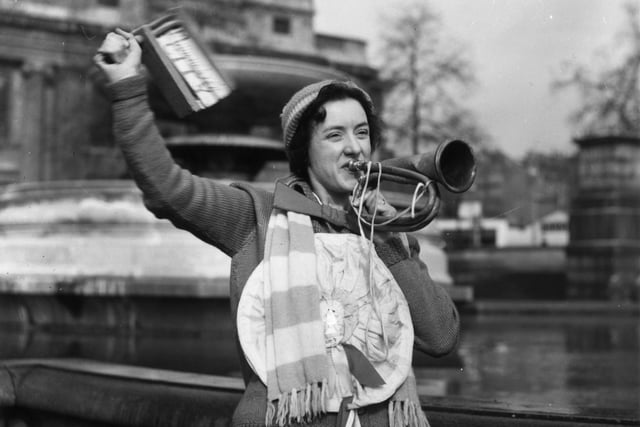 29th April 1939:  A Portsmouth soccer supporter in Trafalgar Square, London blows a horn and waves a rattle. She is in London to watch an FA Cup match.  (Photo by Stephenson/Topical Press Agency/Getty Images)
