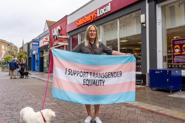Katie Yeomans outside Sainsbury's local, Palmerston Road holding a transgender flag. Picutre: Matthew Clark