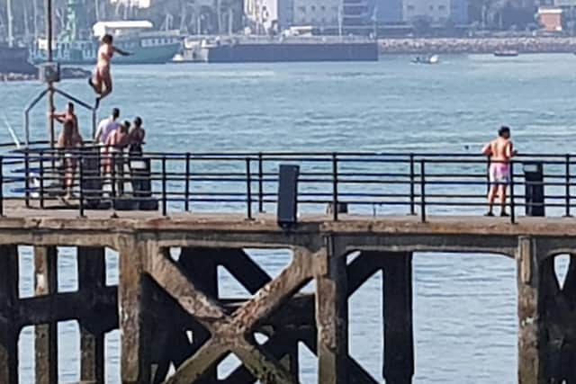 Youngsters tombstoning at Sally Port, Old Portsmouth, on September 6, 2021.