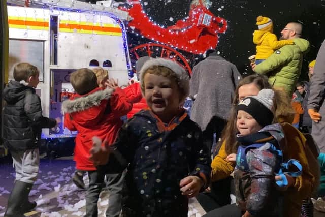 Children pictured playing in the fake snow being pumped out of Santa's sleigh during a festive event at Portchester Castle staged by the town's firefighters.
