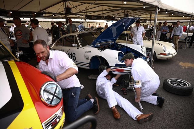 Mechanics repair a classic Porsche following a race during the opening day of Goodwood Revival at the Goodwood Motor Circuit in Chichester on September 8, 2023. The only historic motor race meeting to be staged entirely in a period theme, Goodwood Revival is an immersive celebration of iconic cars and fashion. (Photo by HENRY NICHOLLS / AFP) (Photo by HENRY NICHOLLS/AFP via Getty Images)
