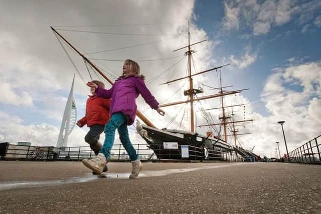Children play outside HMS Warrior.
