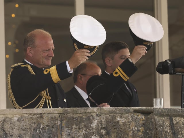 Pictured: Commodore Rob Bellfield gives three cheers from the Royal Yacht Squadron as HMS Queen Elizabeth enters the Solent off of Cowes.