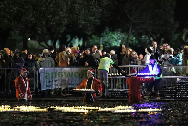 Placing the candles in the lake. Rowans Lake of Lights, Canoe Lake, Southsea in 2019.
Picture: Chris Moorhouse     (151219-36)