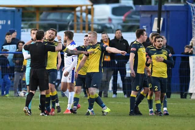 Moneyfields players surround referee Jordan McRitchie following midfielder Callum Glen's first-half sending off Picture: Neil Marshall