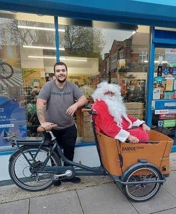Father Christmas accepts the loan of a bike from Southsea Cycles on behalf of Gosport Rotary Club