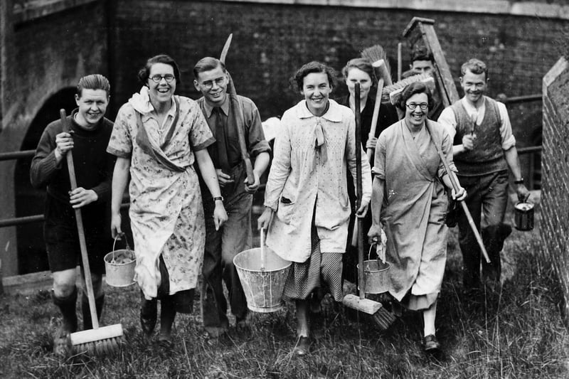 A group of people setting off with brooms and buckets to clean up Fort Purbrook, at the top of Portsdown Hill in, Purbrook, Hampshire, 27th April 1937. (Photo by E. Phillips/Fox Photos/Hulton Archive/Getty Images)