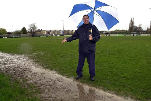 No more umbrella pictures like this at the John Jenkins Stadium! Flashback to 2005 and George Wain shows off a watery Dover Road pitch that resulted in a postponement. Picture: Malcolm Wells