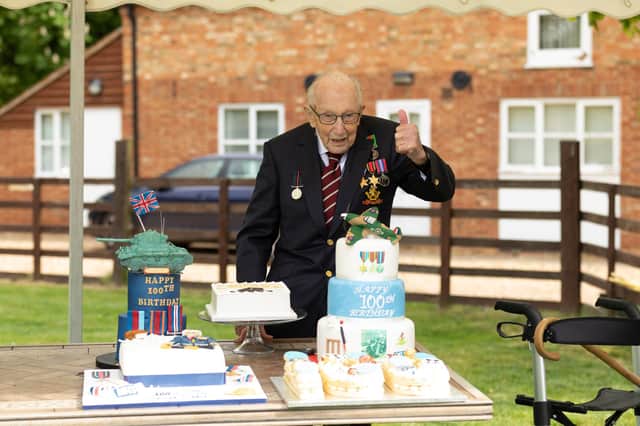 Second World War veteran Captain Tom Moore cutting a cake in the garden as he celebrates his 100th birthday. PA Photo.