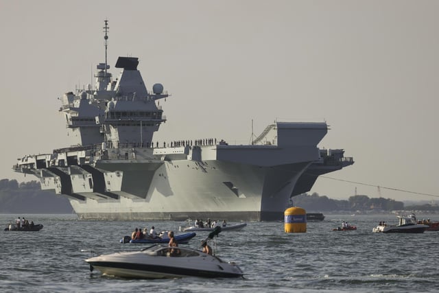 Pictured: HMS Queen Elizabeth enters the Solent off of Cowes and conducts a gun salute in front of the Royal Yacht Squadron.