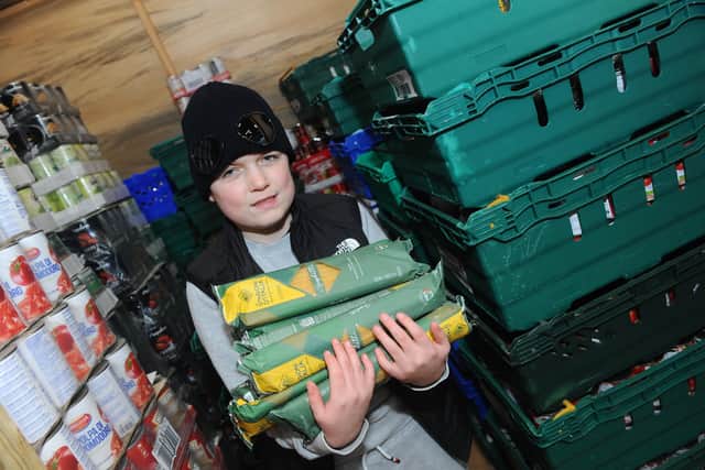 Jacobs Well Care Centre in Toronto Place, Gosport, is taking donations for food, medicine, clothes, and other essentials. Pictured is: Rogan Morrill (12) with some of the food donations. Picture: Sarah Standing (280222-9806).