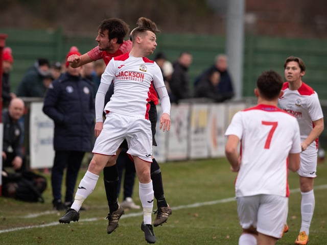 Horndean's Robbie Taw (white) goes up for a header. Picture: Keith Woodland