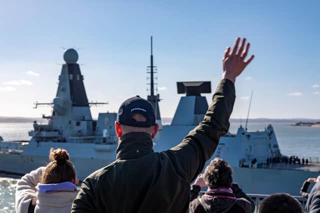 Families and well-wishers wave to the crew of HMS Diamond as she leaves Portsmouth Harbour. Picture: Mike Cooter (250222)