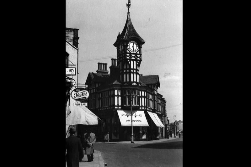The clock tower still remains although the antique shop left some years ago and is now a hairdressers. Road markings are different as well as Great Southsea Street off to the left is now one-way as is Castle Street  on the right to its junction with St Edward's Road out of site on the right. The gentlemen are all smartly dressed with hats of course and the two girls have their best coats on.