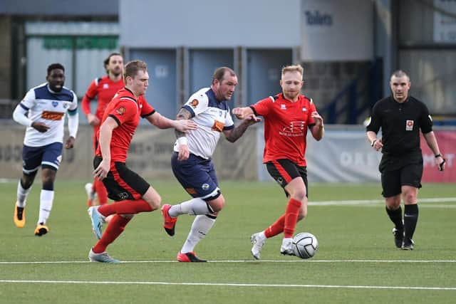 Danny Kedwell breaks forward between two Eastbourne players. Picture: Neil Marshall