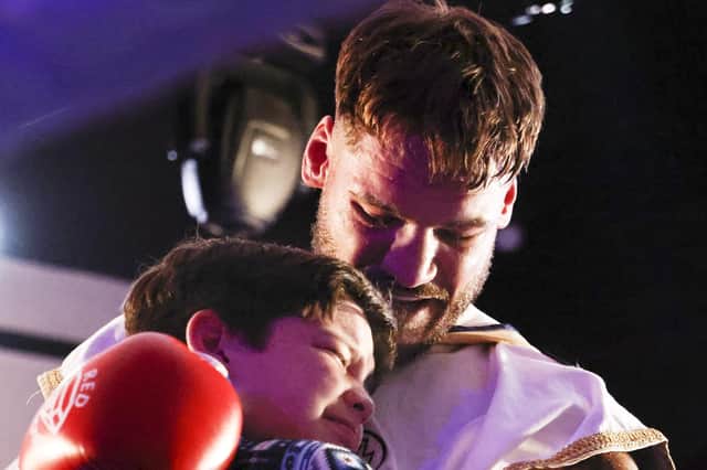 Joel McIntyre, right, shares an emotional moment with son Lucas following his winning return to the ring. Picture: Barry Zee
