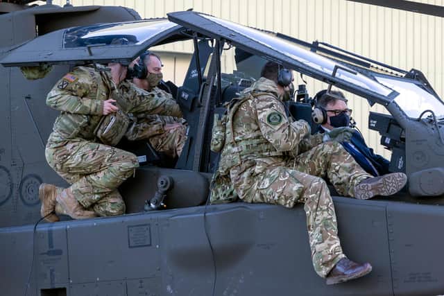 Pilots from 3 Regt, Army Air Corps, explaining parts of the cockpit of an Apache AH64-E to defence procurement minister Jeremy Quin (right) and deputy chief of the general staff Lieutenant General Sir Chris Tickell KBE.