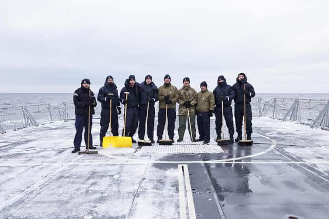 HMS Richmond's flight deck team clear the snow and ice away.