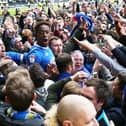 Jamal Lowe is mobbed by visiting Pompey fans after firing the Blues to promotion at Meadow Lane in April 2017. Picture: Joe Pepler